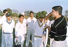 Saurav Ganguly giving batting tips to budding cricketers.