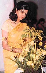 A participant gives final touches to her flower arrangement in