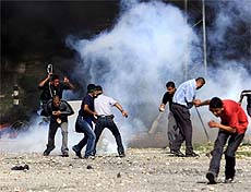Palestinian youths run for cover