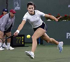 Nathalie Dechy of France returns a shot to Kim Clijsters
