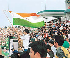 A cricket fan cheers for the Indian team by waving the national flag in the one-day international between India and Zimbabwe at SAS Nagar, Mohali, on Sunday.