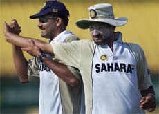 India's spinners Anil Kumble (L) and Harbhajan Singh help each other stretch during a warm-up