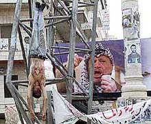 People look at the body of a man alleged to have collaborated with the Israelis