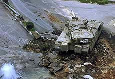 An Israeli tank takes position near a burst water pipe
