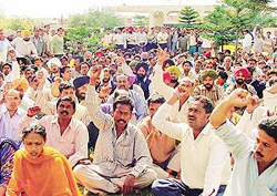 Employees of JCT Electronics Limited, SAS Nagar, protest against the lockout of the unit outside the factory premises on Wednesday.