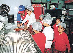 Children of Strawberry Fields School have fun as they take over the kitchenette of a popular pizza outlet in Sector 34, Chandigarh, on Wednesday.