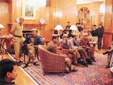 Policemen who had gone to evict the staff of the Oberois from the Wildflower Hall hotel, near Shimla, on Wednesday sit in the lobby late on Wednesday evening.