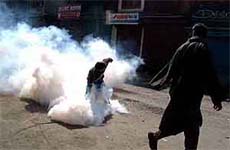 Youth returning a tear gas shell towards police 