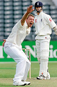 England batsman James Foster (R) looks on as New Zealand bowler Chris Drumm appeals successfully for a leg before wicket ruling 