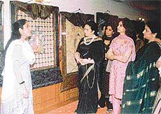  Amrita explains the details of her paintings to visitors