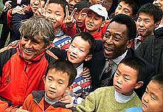 Brazilian soccer legend Pele and Chinese national soccer team coach Bora Milutinovic pose with Chinese children