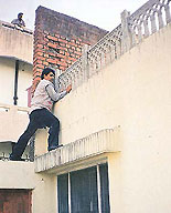 A CBI official climbs a wall of the �house� of the UT Assistant Excise Taxation Commissioner, S.P. Kansal, during a raid in Parwanoo on Saturday.