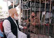 Qazi Hussain Ahmed, left, chief of Pakistan's right-wing Islamic party Jamat-e-Islami, Party of Islam offers condolences to Christian leader father Julius Salik on Monday in Islamabad, Pakistan for slain worshippers in Sunday's church attack. 