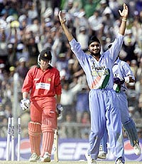 Harbhajan Singh (R) celebrates the stumping of Zimbabwe's batsman Travis Friend