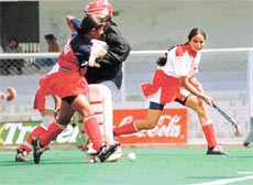 Jasjeet Kaur of Haryana dodging Neena (goalkeeper) of Madhya Pradesh during the 51st Senior Women�s National Hockey Championship in Jalandhar on Tuesday.