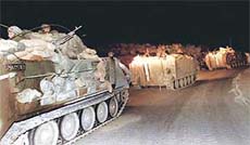 Israeli armored personnel carriers leave in a convoy