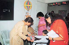 The president of the Western Command Army Wives Welfare Association (AWWA), Ms Deep Surjit Singh, presents a gift to a student of Asha School in Chandi Mandir on Wednesday. 