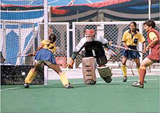 Karnatka's goalkeeper K. J. Kusuma tries to stop the ball