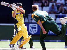 Australian batsman Adam Gilchrist (L) hits a delivery