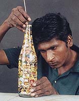 Artist Mayapandi paints the inside of a bottle