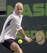 Andre Agassi returns a shot from Greg Rusedski of Britain