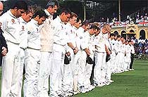 England and New Zealand players and officials observe a moment of silence for England player Ben Hollioake 