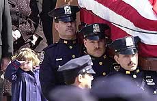 Patricia Smith, 2, left, salutes as the flag-draped casket bearing her mother, New York City police officer Moira Smith, is carried