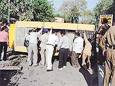 Policemen and voluntary rescue workers try to push a bus into normal position. The bus overturned in Ludhiana on Tuesday