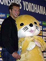 Australian swimming champion Ian Thorpe poses with a mascot doll