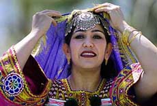 Fatima Sultani adjusts her veil to keep the sun off her face at the Afghan New Year's celebration in Pleasanton, Calif, on Saturday.