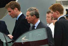 Britain's Prince Charles and his sons Princes William and Harry arrive back in the United Kingdom