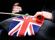 A well-wisher holds a Union Jack flag
