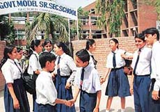 Friends greet each other on the opening day of the new academic session at a school 