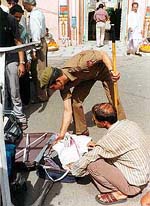 A policeman searches a briefcase outside Raghunath Temple 