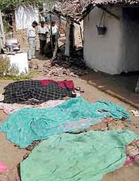 The police stands near charred bodies at Ambasana village