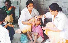 Volunteers administer polio drops to a child during a drive in Ludhiana.