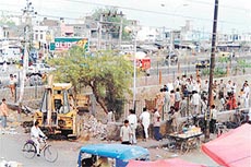 An MC bulldozer pulls down a tree and part of the boundary wall in a park near the Salem Tabri locality to make way for entrance to a parking lot in Ludhiana on Thursday.