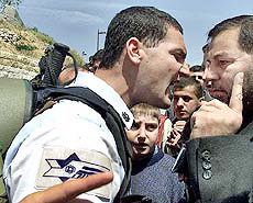 An Israeli policeman and an Israeli Arab argue 