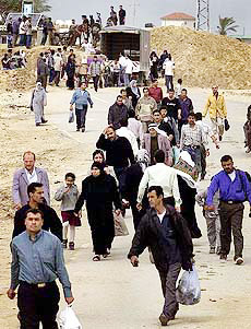 Palestinians pass an Israeli checkpoint after the Israeli army blocked the road between north and south Gaza strip near the Jewish settlement of Netzaeim on Saturday.