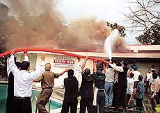 Firemen and hotel workers try to control the fire that broke out at the Health Club of Hotel Mountview in Chandigarh on Sunday.