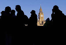 People are silhouetted against the Houses of Parliament