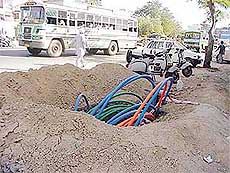 Optical fibre cables protrude from a berm of a road being dug by the Reliance Group affecting flow of traffic in Ludhiana.