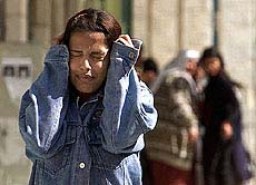 A Palestinian girl covers her ears