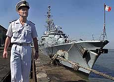 Senior French naval officer George Murant walks past French Naval ship