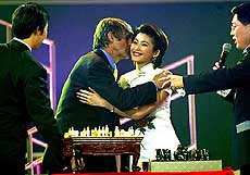 Chinese national soccer team coach Bora Milutinovic kisses hostess Wang Xiaoya after receiving a gift for bringing the Chinese soccer team into the World Cup finals during a ceremony in Beijing on Tuesday.