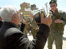 A catholic priest shows his Bible as he is prevented from entering the West Bank city of Bethlehem by an Israeli soldier 