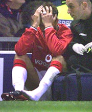 Manchester United's David Beckham sits with his head in his hands accompanied by a team physiotherapist after getting injured against Deportivo La Coruna during their Champions League quarterfinal second leg match at Old Trafford on Wednesday. 