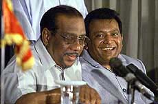 Velupillai Prabhakaran (R), leader of the Liberation Tigers of Tamil Eelam (LTTE), looks at his spokesman Anton Balasingham during a news conference