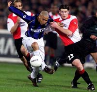 Inter Milan player Ronaldo, left, and Brett Emerton of Feyenoord challenge for the ball 