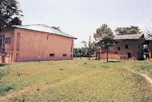 Norah�s mud house beside a newly constructed building.